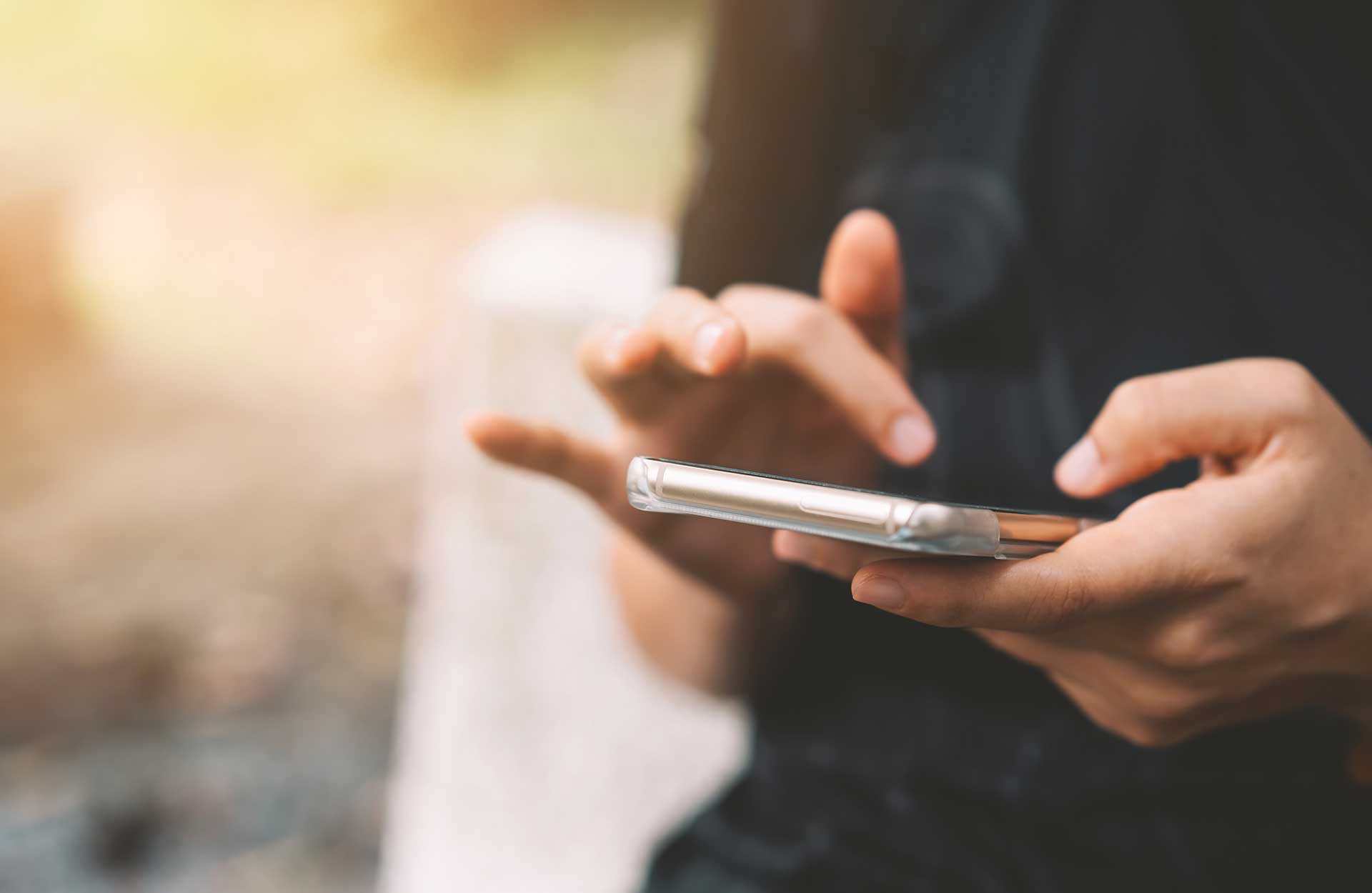 close up of hands using cell phone